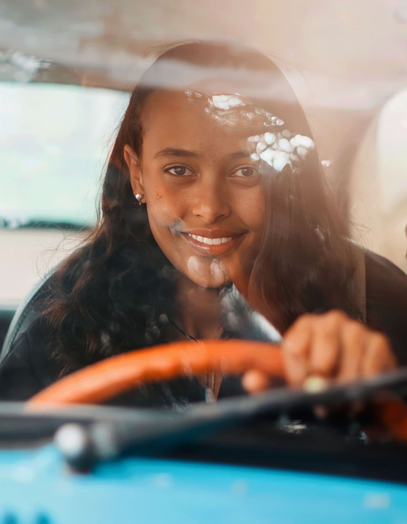 A driver smiling behind the wheel, back on the road